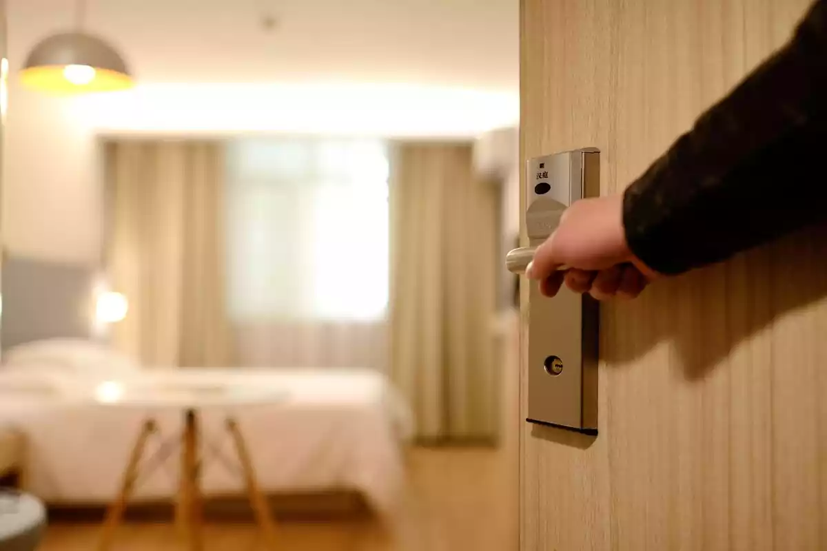 Hombre abriendo la puerta de una habitación de hotel